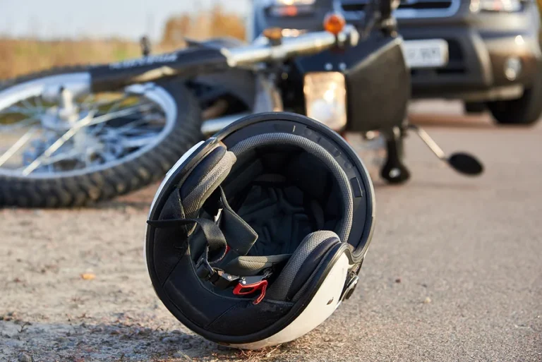 Photo of car, helmet and motorcycle on road, the concept of road accidents.