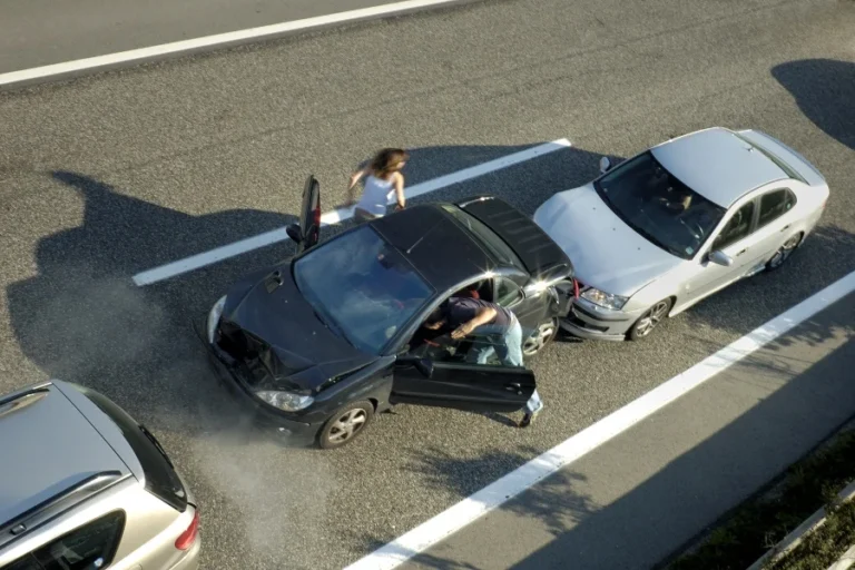 a small shunt on the freeway (motorway autoroute autobahn) a few seconds after it happened. steam can be seen coming from under the bonnet of the black car. motion blur on the passenger fleeing in panic.