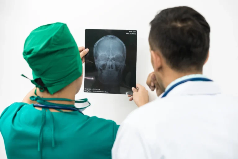 Doctor and surgeon examining x-ray film of patient 's head for brain skull or eye injury. Medical diagnosis and surgical treatment concept.