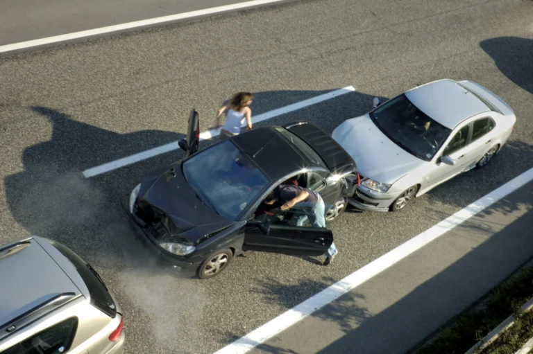 a small shunt on the freeway (motorway autoroute autobahn) a few seconds after it happened. steam can be seen coming from under the bonnet of the black car. motion blur on the passenger fleeing in panic.