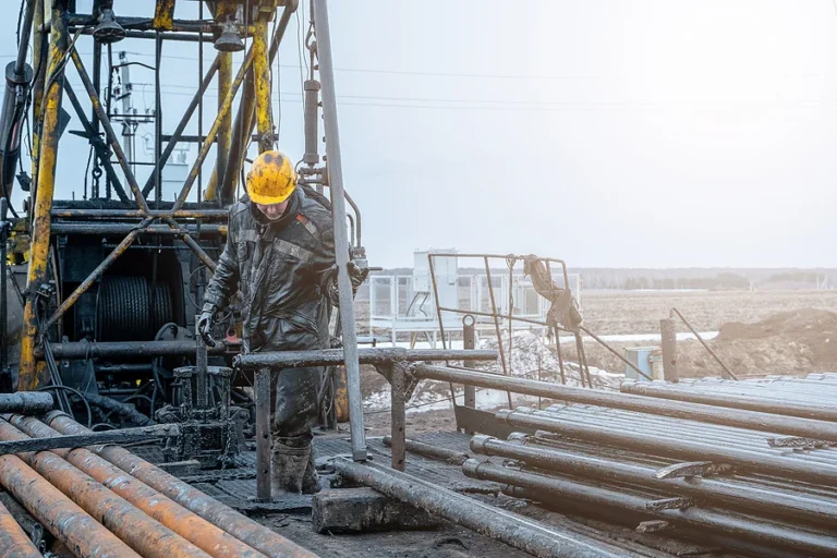 Workover rig working on a previously drilled well trying to restore production through repair. Offshore oil rig worker prepares tool and equipment for perforation oil and gas well at wellhead platform.